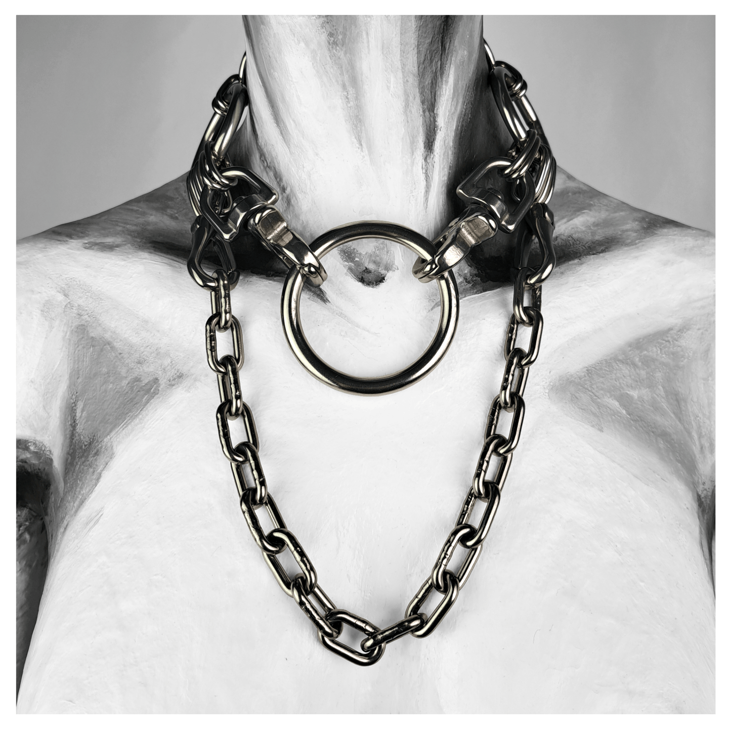 FROSTGLANZ brutalist necklace featuring central stainless steel ring held by two carabiners, flanked by a detachable chain and finished with a reclaimed leather neckpiece — shown on mannequin, handcrafted by skinpressedtight