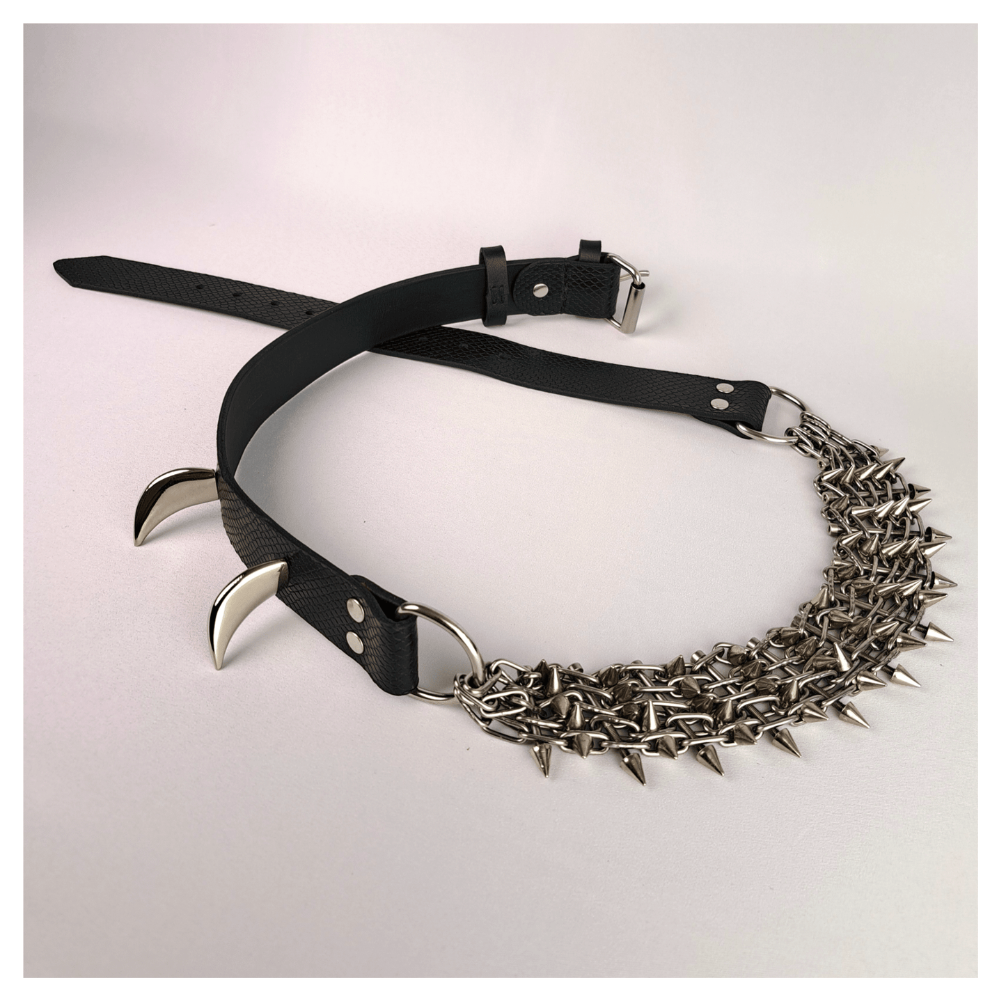 KLINGENSÄNGER — VIPER edition belt laid out on white background, featuring black viper print leather, metal chainspike hardware, and prominent fang studs — handcrafted gothic statement piece by skinpressedtight