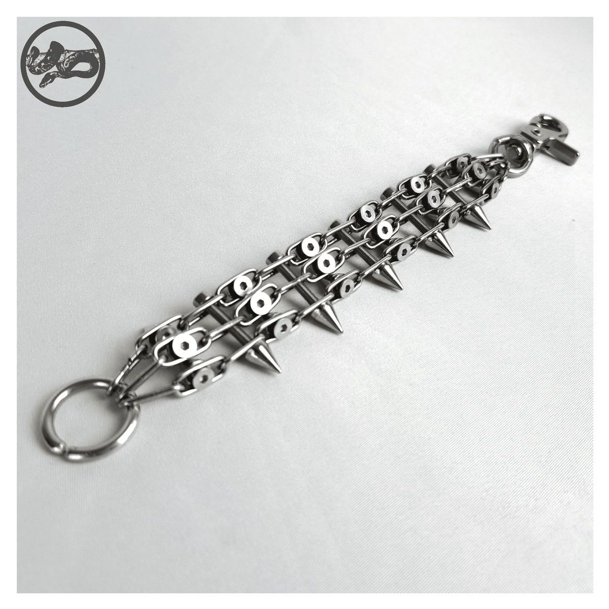 SCHALTKREIS spiked bracelet open on white, back: the countersunk screw heads holding the chain ladder together, O-ring and carabiner closure. Handmade by skinpressedtight