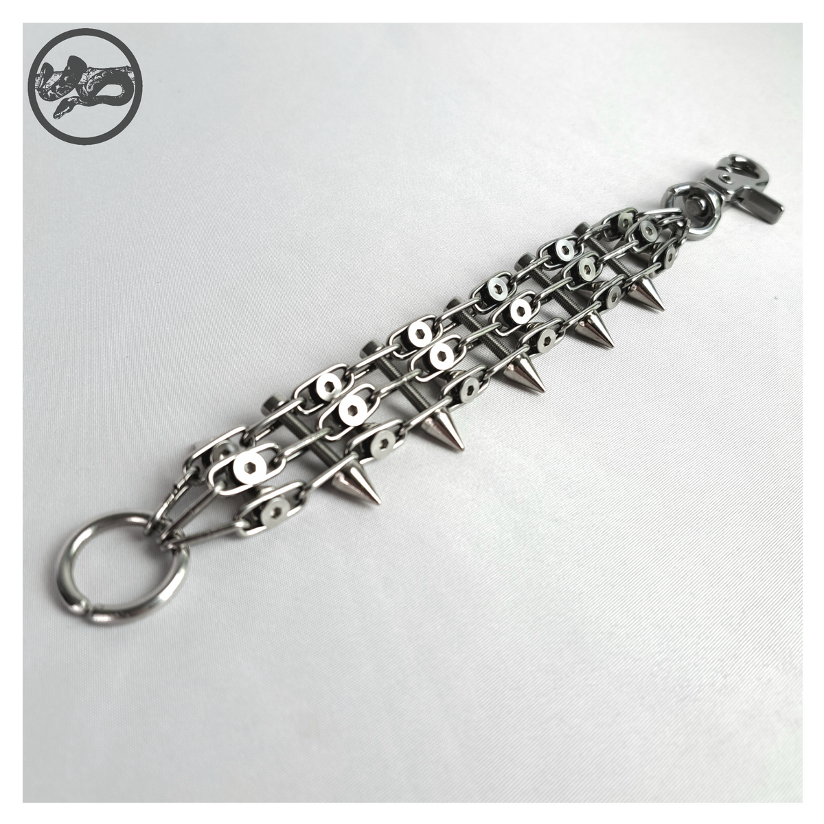 SCHALTKREIS spiked bracelet open on white, back: the countersunk screw heads holding the chain ladder together, O-ring and carabiner closure. Handmade by skinpressedtight