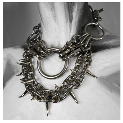FEGEFLAMME brutalist necklace on mannequin, featuring studded stainless steel chains with small zinc alloy claw spikes, a central O-ring, and a reclaimed leather neckpiece fastened with stainless steel carbines — gothic handcrafted accessory by skinpressedtight.