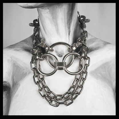FLAECHENBRAND brutalist necklace featuring layered stainless steel rings clasped by carbines, flanked by chains, and a detachable reclaimed leather neckpiece — displayed on white mannequin, handcrafted by skinpressedtight