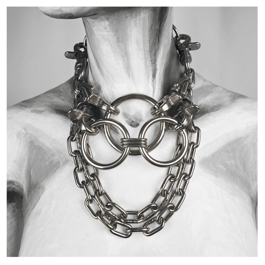 FLAECHENBRAND brutalist necklace featuring layered stainless steel rings clasped by carbines, flanked by chains, and a detachable reclaimed leather neckpiece — displayed on white mannequin, handcrafted by skinpressedtight