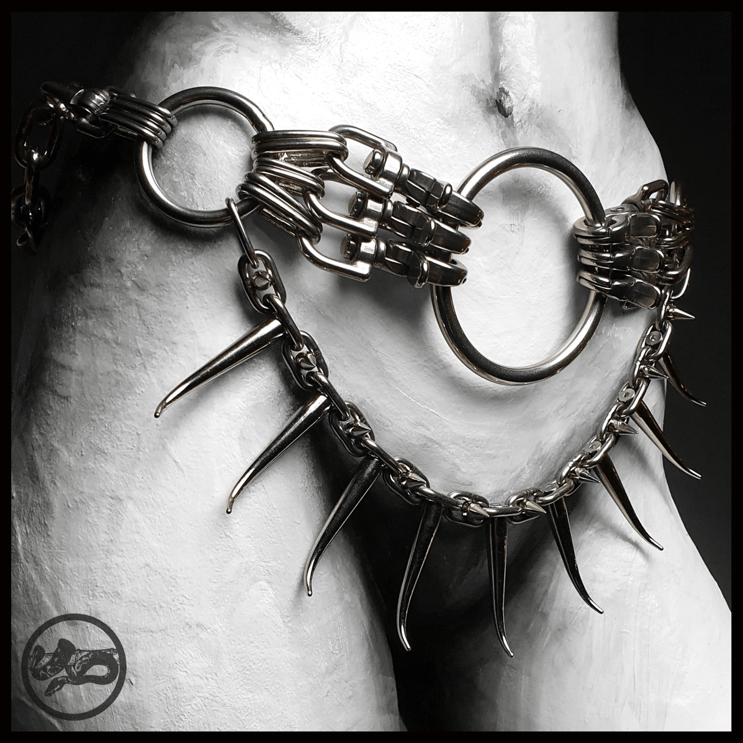 MYRAPOD - SPINNENLÄUFER belt in brutalist design with spiked chain, handcrafted from stainless steel. This edition is extended with a chunky chain, spiked with huge zinc alloys claw studs — shown worn on mannequin, alternative statement piece by skinpressedtight