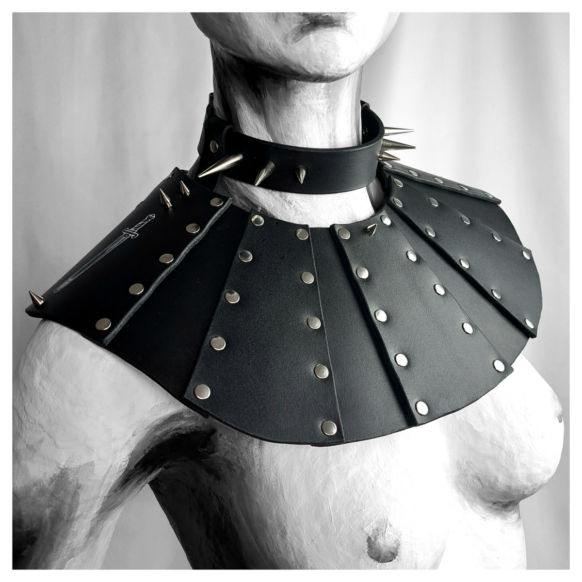 BLUTSPUR leather gorget worn on a painted mannequin: fanned black leather panels edged with rows of silver rivets over the shoulders, a spiked leather neck strap above. Handmade by skinpressedtight