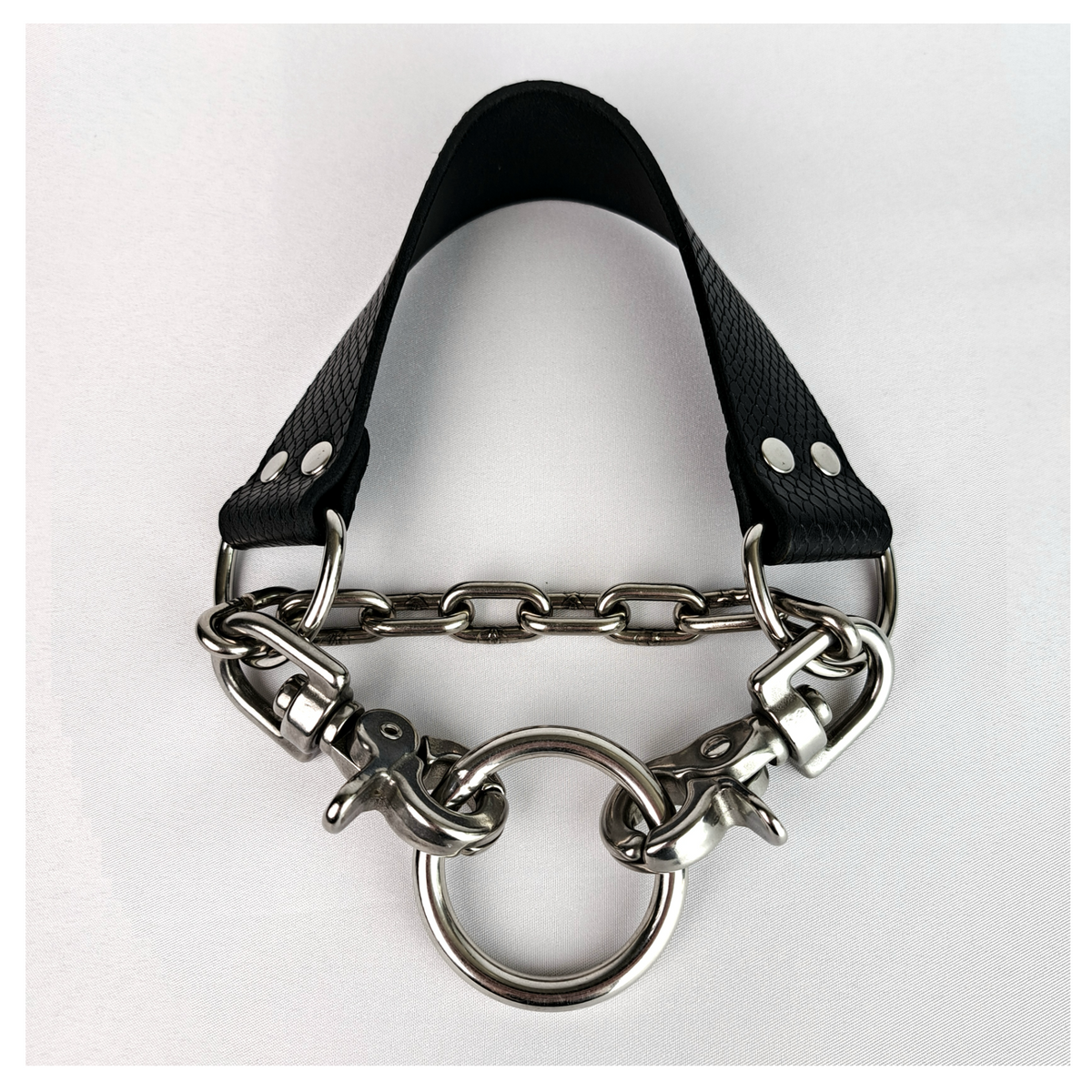 BOAKAPITEL – III. BLACK VIPER choker closed on white: black viper-embossed leather band with D-rings, short-link chain and two scissor carabiners clipped into a 40 mm O-ring. Handmade by skinpressedtight