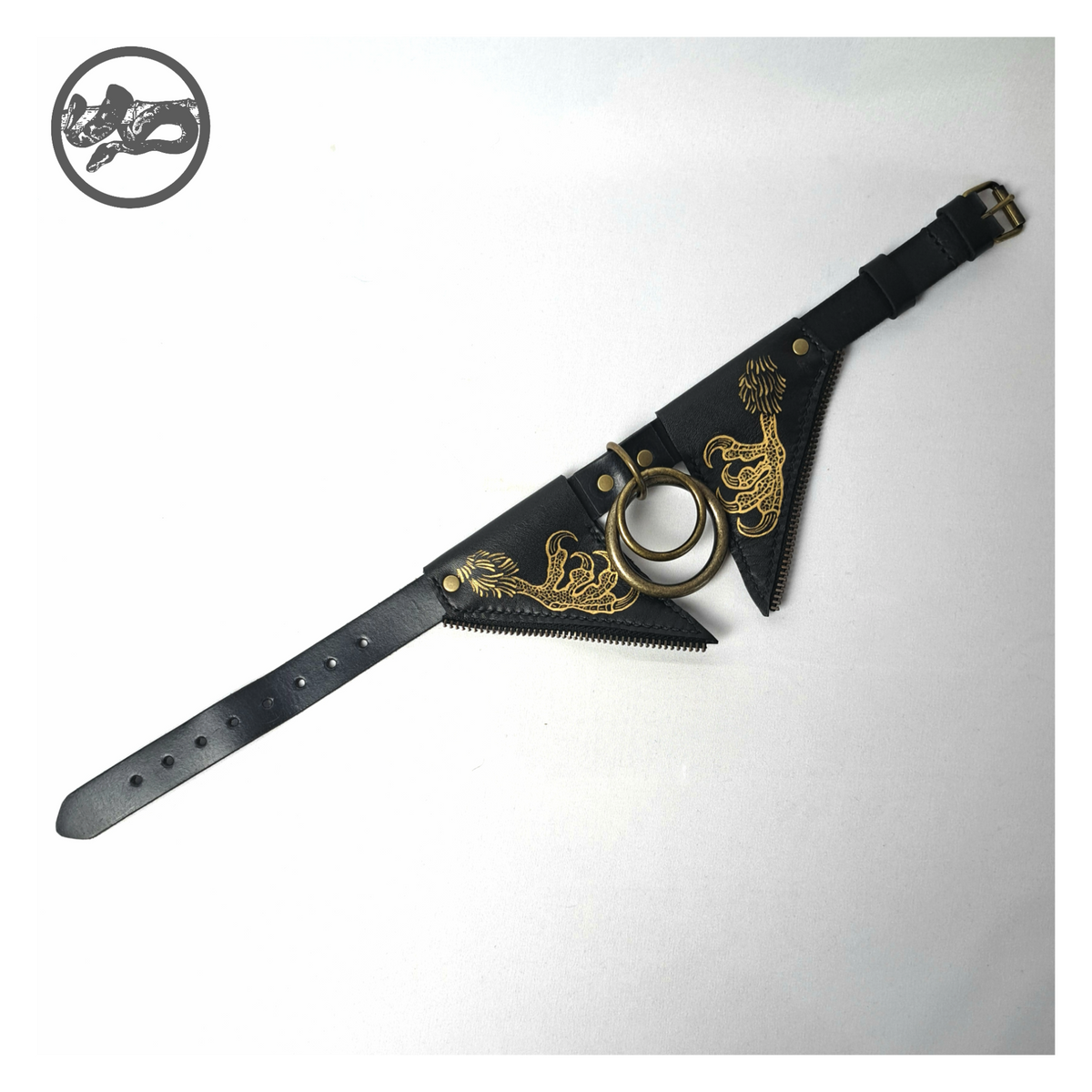 FLEDERTIER – BABA JAGA leather choker laid out open: flap painted with gold chicken feet, brass rings and the black strap with an antique-brass roller buckle. Handmade by skinpressedtight
