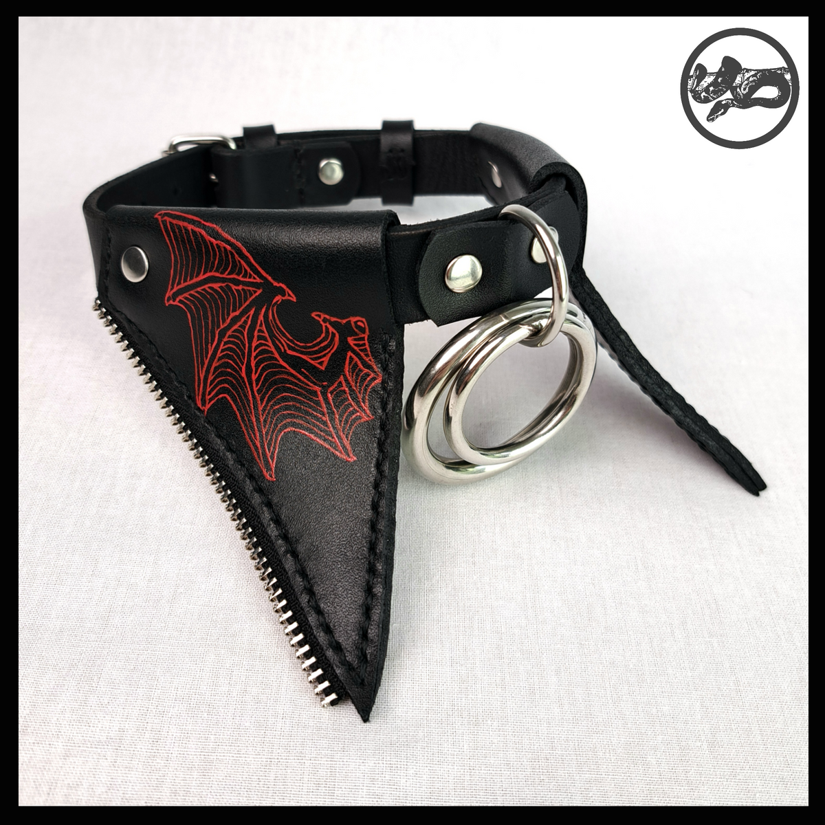 FLEDERTIER – SABBATH leather choker closed, on white: red-painted black leather flaps edged with silver zip teeth and the nested stainless rings. Handmade by skinpressedtight
