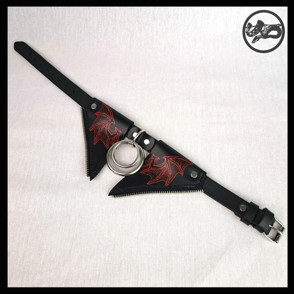 FLEDERTIER – SABBATH leather choker laid out open: the red-painted wing flaps, stainless double ring and the black strap with a roller buckle. Handmade by skinpressedtight