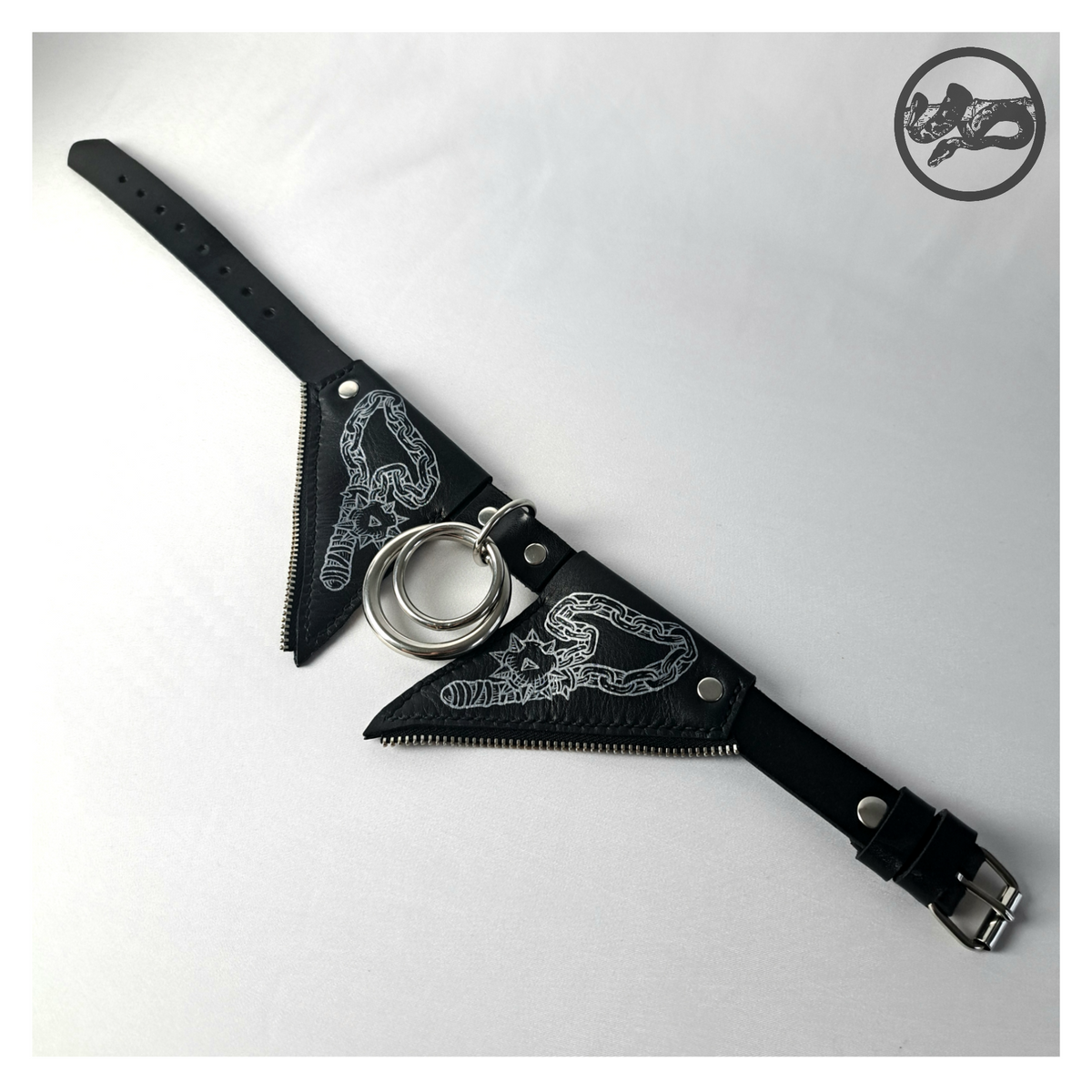 FLEDERTIER – SMITE leather choker laid out open: the white-painted wing flaps, silver rings and the black strap with a roller buckle. Handmade by skinpressedtight