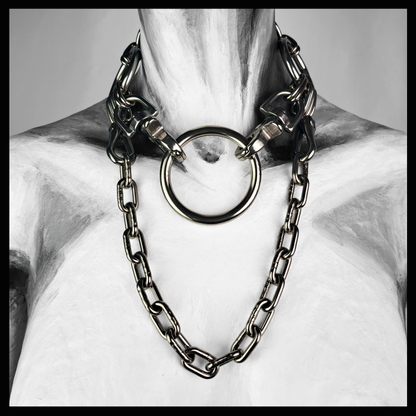 FROSTGLANZ chain necklace worn on a painted mannequin, black and white: a large stainless O-ring at the throat with a heavy short-link chain draped beneath it onto the chest. Handmade by skinpressedtight