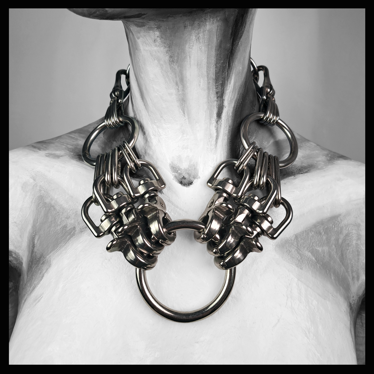 HEXAPOD statement necklace worn on a painted mannequin, black and white: clusters of polished stainless steel scissor carabiners gripping a large central O-ring, hanging from a black leather neckpiece. Handmade by skinpressedtight