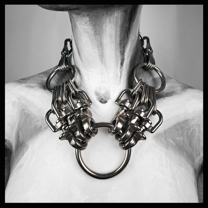 HEXAPOD statement necklace worn on a painted mannequin, black and white: clusters of polished stainless steel scissor carabiners gripping a large central O-ring, hanging from a black leather neckpiece. Handmade by skinpressedtight