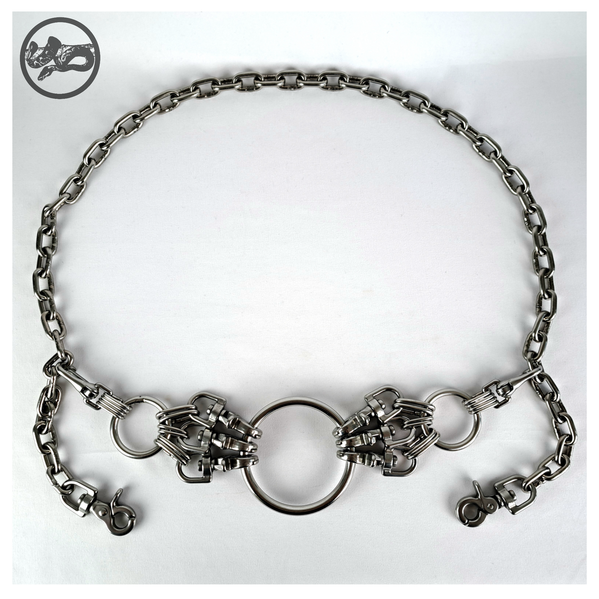 MYRAPOD chain belt laid out flat on white: the whole belt with its large O-ring, carabiner clusters, 40 mm side rings and the long stainless chain with rein hooks at both ends. Handmade by skinpressedtight