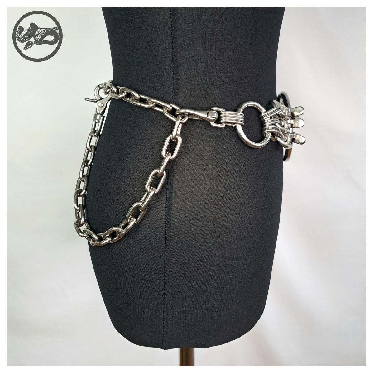 MYRAPOD chain belt on a black dress form, side view: stainless steel short-link chain draping at the hip from the carabiner cluster, rein hook closure. Handmade by skinpressedtight