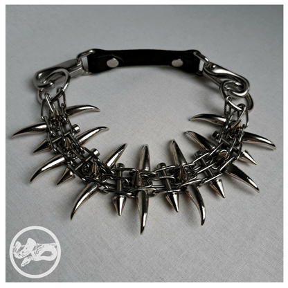 QUERULANT choker necklace made of reclaimed leather and metal hardware, displayed from the front on table — edgy, handcrafted gothic accessory.
