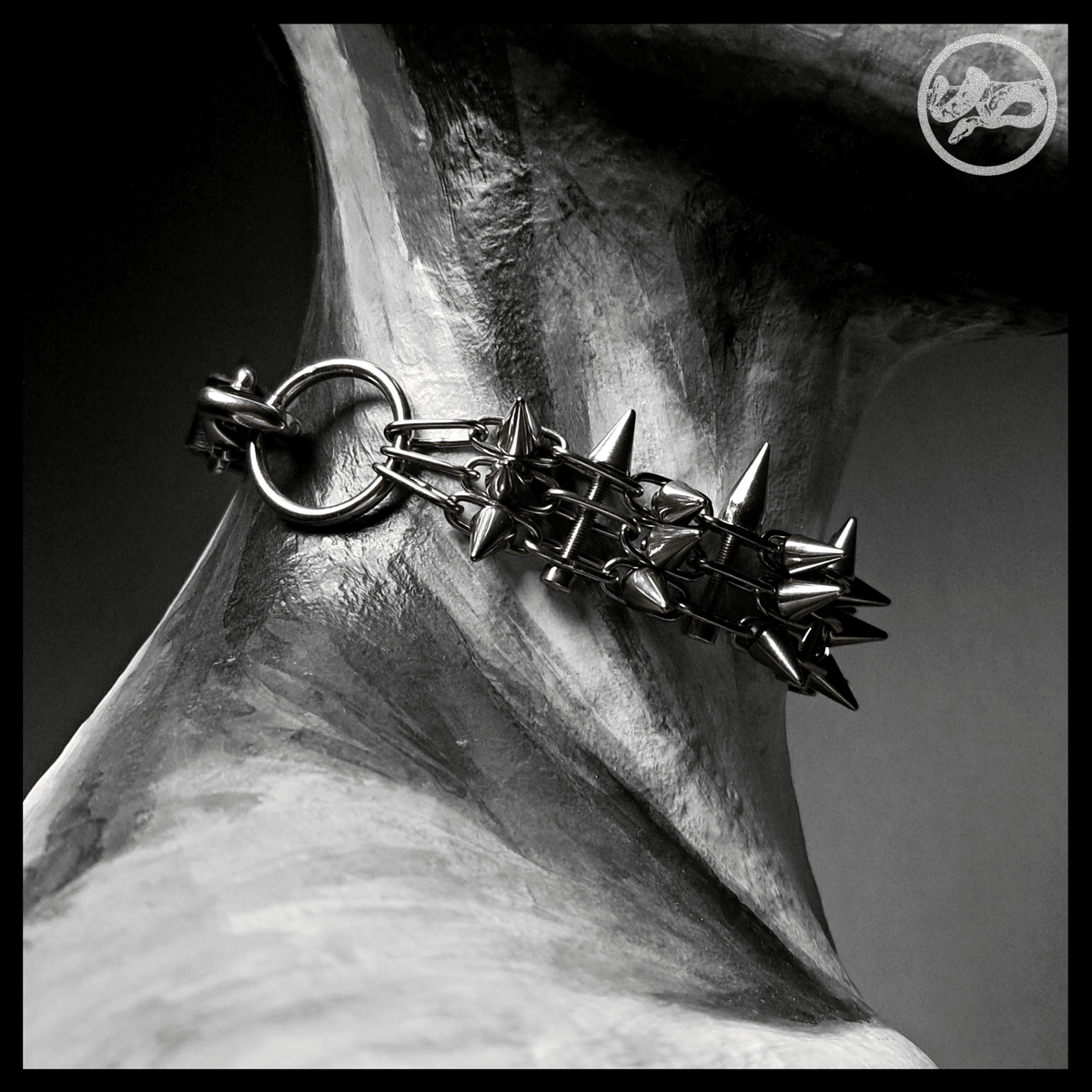 STŌRENFRIED choker worn, from behind: a stainless O-ring and snap hook joining the spiked band to the leather strap. Handmade by skinpressedtight
