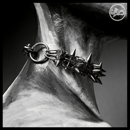 STŌRENFRIED choker worn, from behind: a stainless O-ring and snap hook joining the spiked band to the leather strap. Handmade by skinpressedtight