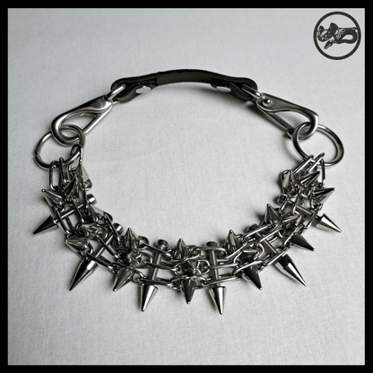 STŌRENFRIED choker laid flat from above: the spiked chain band, O-rings and the black leather back strap with snap hooks. Handmade by skinpressedtight
