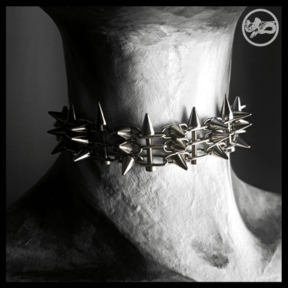 STŌRENFRIED spiked chain choker worn on a painted mannequin, front view: spikes all around the throat. Handmade by skinpressedtight