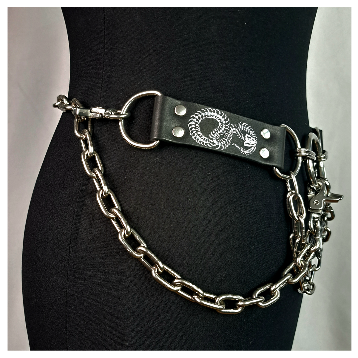 VIPERNZIRKEL – BONES chain belt on a dress form, other side: painted snake-skeleton tab, D-ring and chain round the hip. Handmade by skinpressedtight