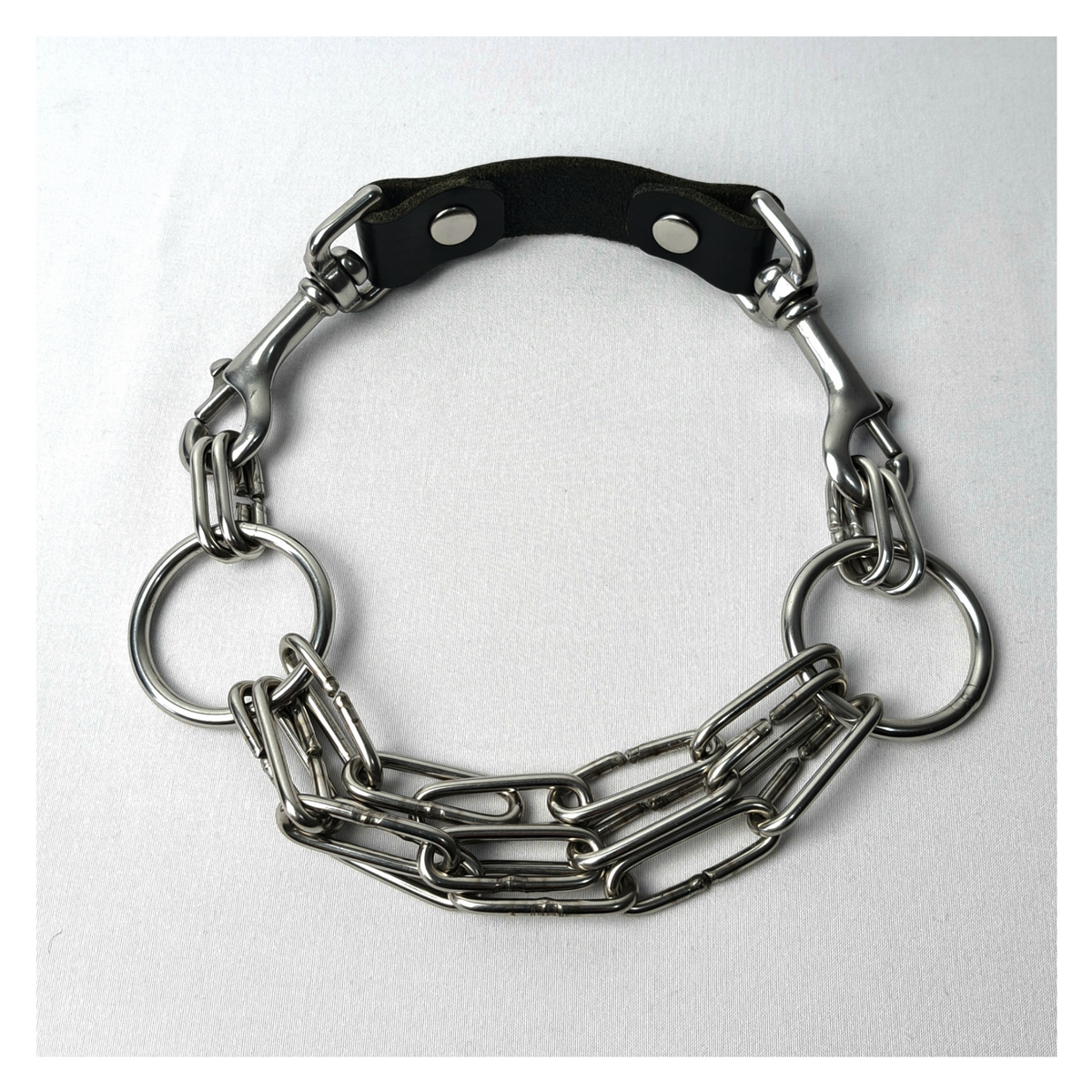 WARNSCHUSS chain necklace closed on white: three parallel strands of chunky stainless chain, 30 mm O-rings at the sides and a black leather neckpiece with bolt snaps at the back. Handmade by skinpressedtight