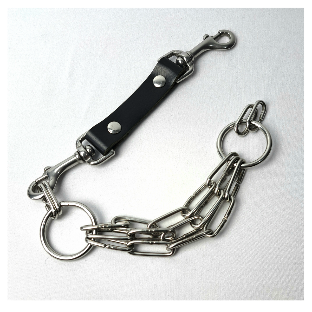 WARNSCHUSS chain necklace open, front: the black leather strap with a stainless bolt snap at each end, one unclipped from its O-ring, and the three long-link chain strands. Handmade by skinpressedtight